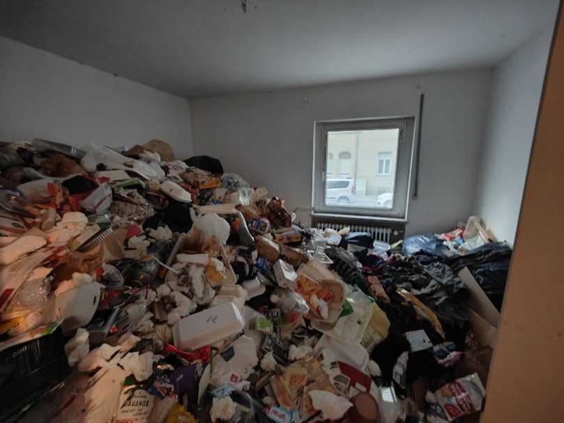 Wohnraum mit großflächiger Vermüllung in einer Messie-Wohnung vor der Wohnungsräumung
